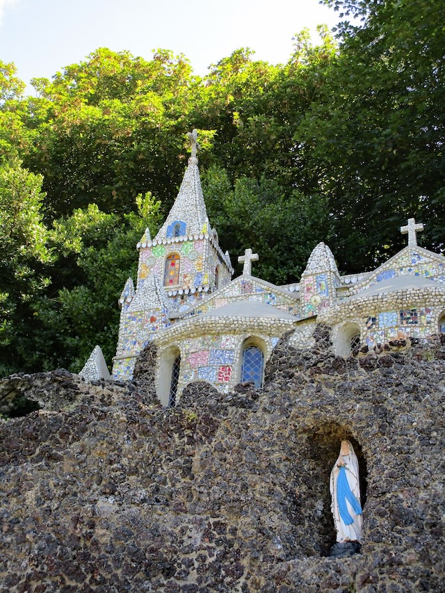 The vibrant colors of The Little Chapel’s mosaic-covered facade stand out against the natural landscape.