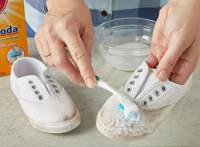 Cleaning white canvas shoes with a toothbrush and baking soda – a classic, tried-and-true method for keeping them looking brand new