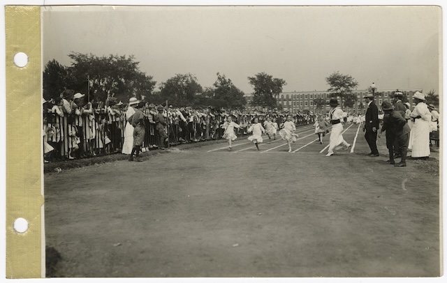 A vintage snapshot capturing the final sprint of a Field Day race, as children dash towards the finish line while spectators cheer from the sidelines, embodying the excitement of friendly competition