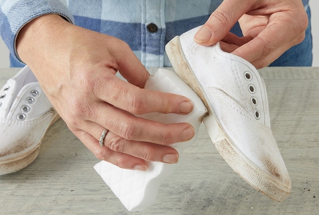 Using a magic eraser to scrub away stubborn dirt on white sneakers, bringing them back to life with just a little effort