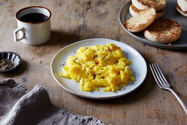 Fluffy scrambled eggs served with a cup of coffee and English muffins. Is this the result of adding milk, or does it stick to the egg purists’ method?