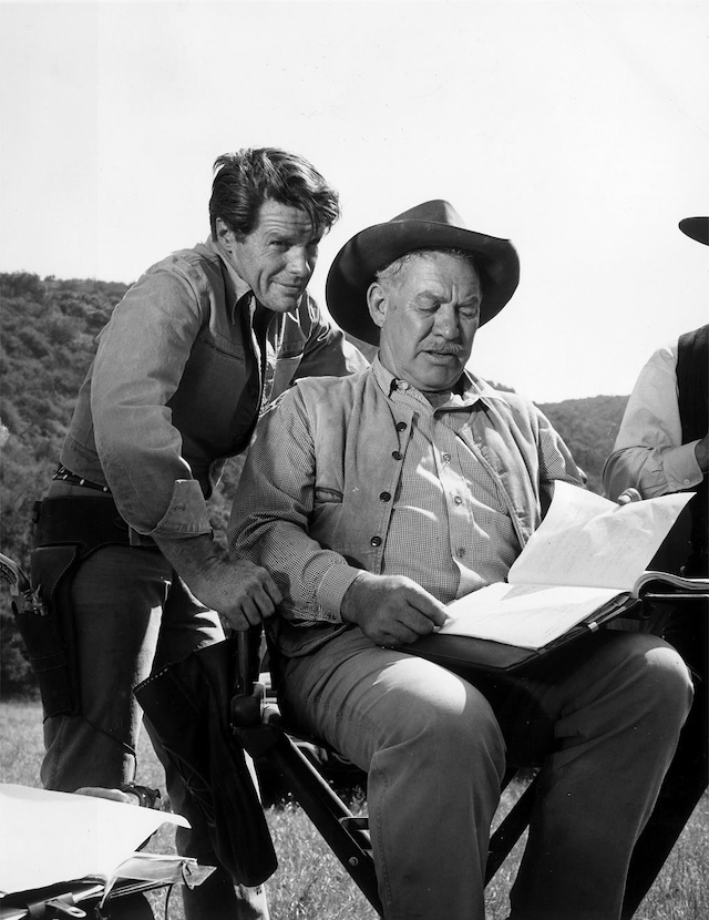 Actors Robert Horton and Ward Bond discuss a scene during a break in filming the popular Western series.