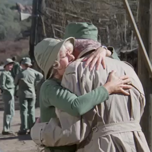 An emotional embrace between Margaret and a close friend, symbolizing the deep bonds formed under the pressure of war, and the bittersweet farewells they face