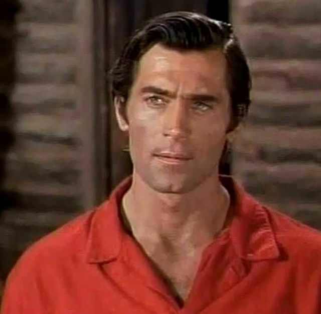 Clint Walker in a rare image from his younger years, showcasing his handsome features and screen presence.