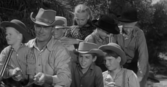 A scene from The Rifleman episode "The Schoolmaster," where Chuck Connors' character, Lucas McCain, gives a ride to a group of kids, including his real-life sons