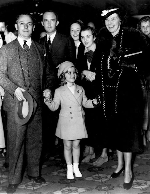 Shirley Temple poses with her family during a public event, showcasing her early fame and the support from her parents