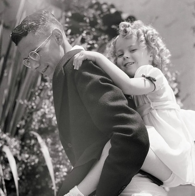 Shirley Temple shares a tender moment with her eldest brother, John, whose quiet strength and support were instrumental in helping her navigate her early fame