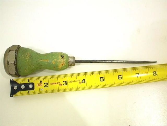 A green-handled vintage awl, carefully measured for scale, showcasing its sharp, pointed tip