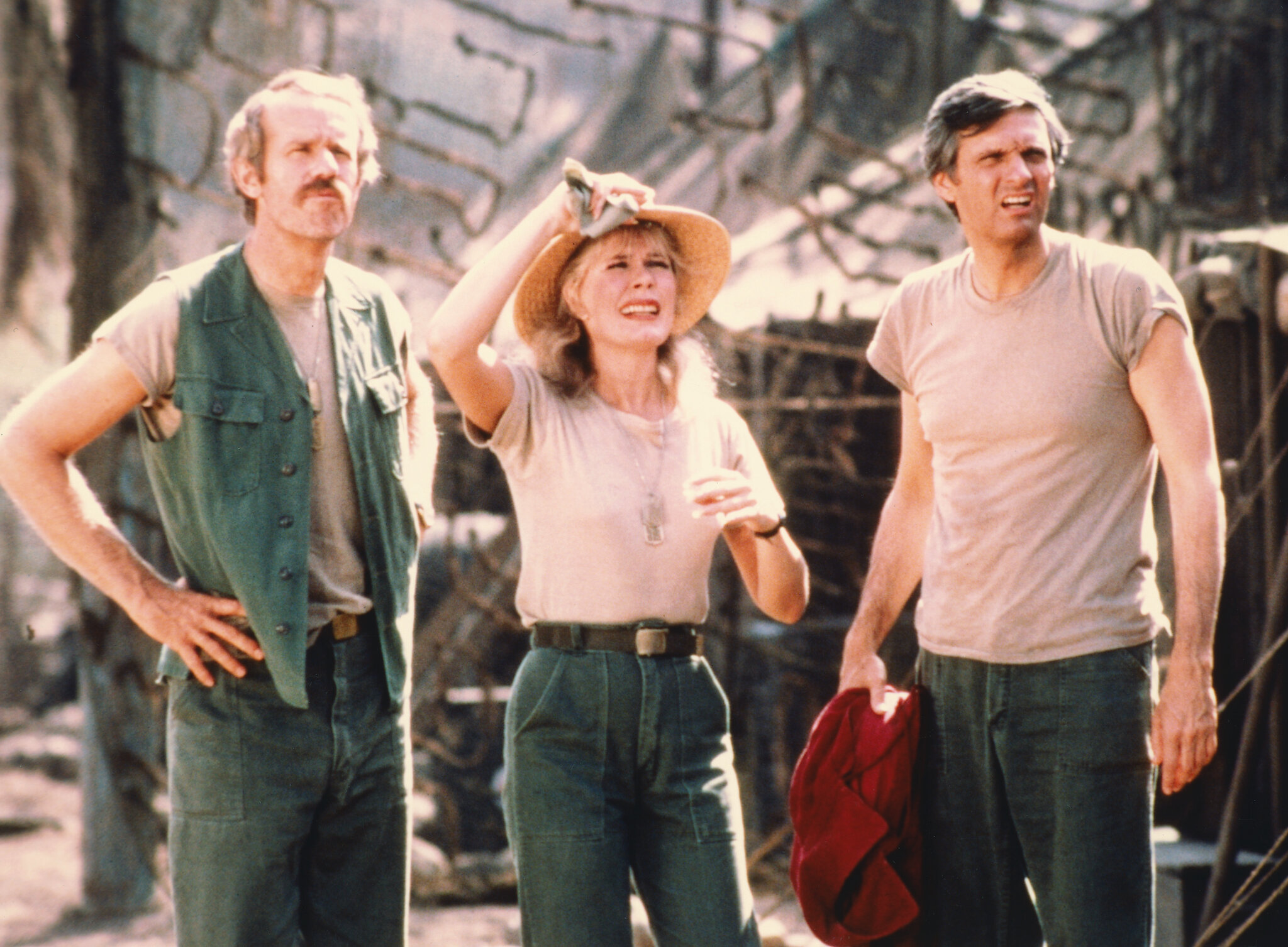 Mike Farrell, Loretta Swit (Major Margaret Houlihan), and Alan Alda in a still from M*A*S*H, showcasing the strength and dynamic between the characters during a mission in the Korean War