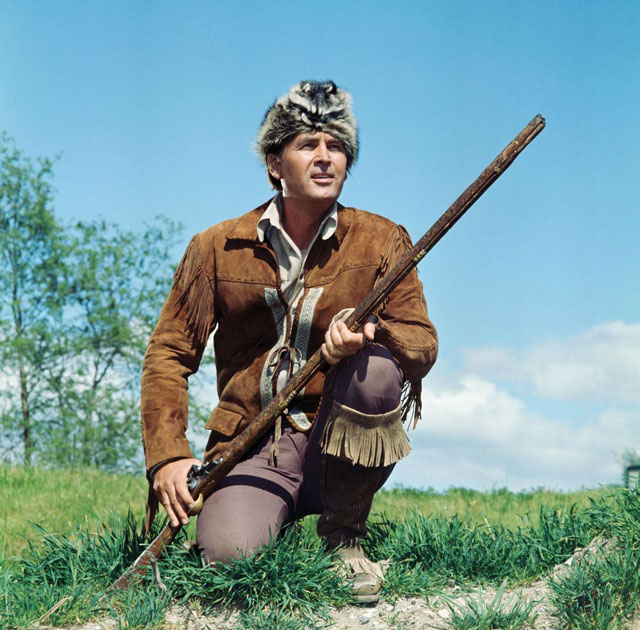 Fess Parker as the legendary Daniel Boone, complete with his coonskin cap and rifle, ready for adventure.