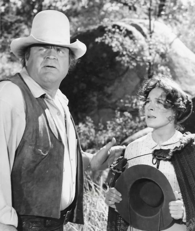 Dan Blocker as Hoss Cartwright, concerned and protective, standing beside a worried woman in a scene from Bonanza