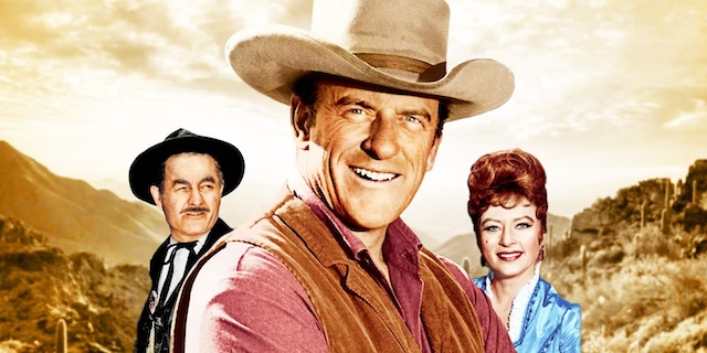 James Arness as Marshal Matt Dillon stands at the forefront in this promotional image, flanked by familiar faces from Gunsmoke—Ken Curtis as Festus Haggen and Amanda Blake as Miss Kitty