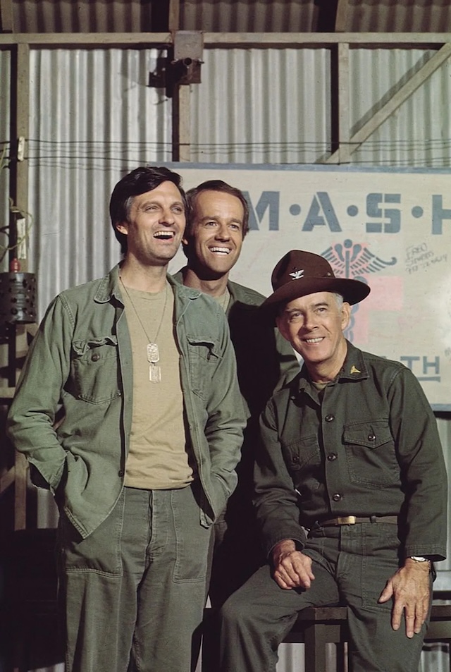 M*A*S*H Trio: A memorable shot of Alan Alda (Hawkeye), Mike Farrell (B.J.), and Harry Morgan (Colonel Potter) on the set of M*A*S*H, showing camaraderie and friendship between the characters and actors