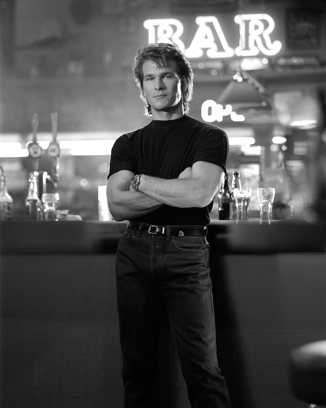 A classic black-and-white shot of Patrick Swayze as Dalton, exuding the cool, calm demeanor of the legendary bouncer in "Road House."