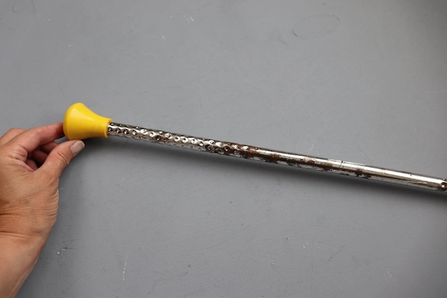 This well-worn twirling baton shows signs of years of use, a testament to its durability and the rigorous practice routines of majorettes who once performed with it