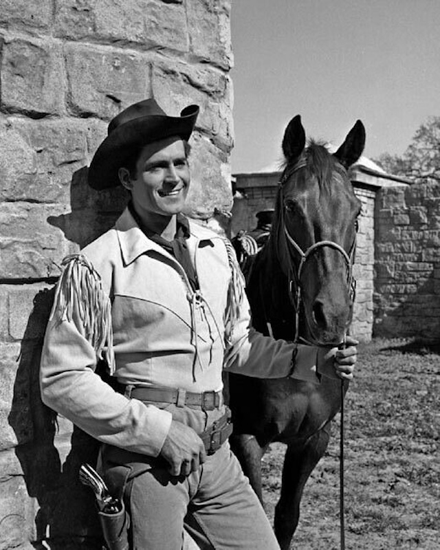 Clint Walker standing tall next to his trusty horse - Cheyenne Bodie, the Western hero, always ready for action.