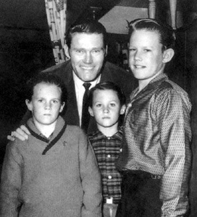 Chuck Connors smiles with his three sons, capturing a family moment outside of the TV screen