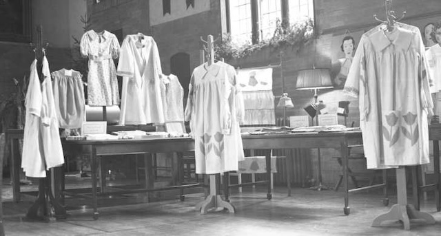 A display of finished sewing projects, with beautifully crafted garments ready for evaluation or presentation at a school fair.