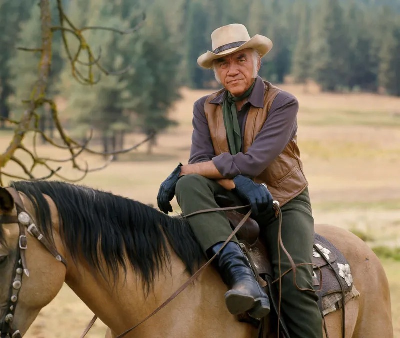 Lorne Greene as Ben Cartwright sitting on his horse with a commanding presence in the wide-open landscape of Nevada