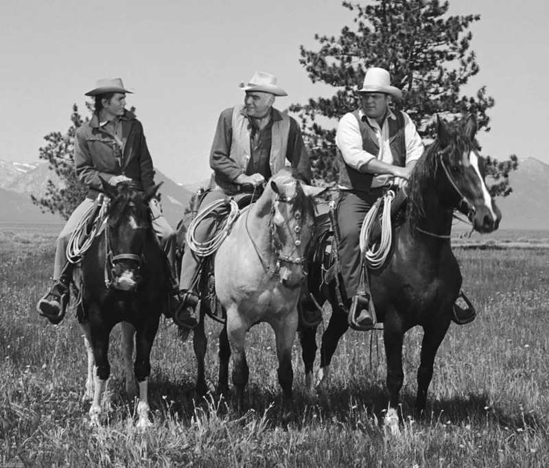 The three Cartwright men — Little Joe, Ben, and Hoss — riding side by side across the fields of the Ponderosa Ranch