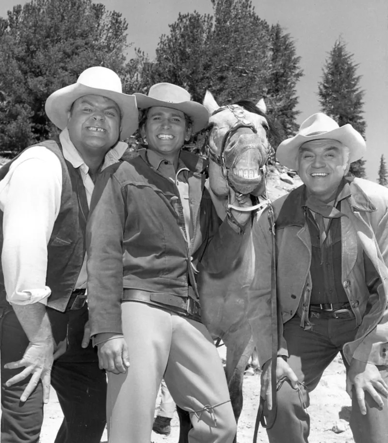 A fun and candid moment with the Cartwrights, smiling alongside a horse, capturing the playful side of Bonanza