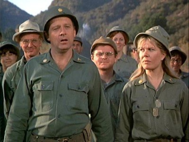 The M*A*S*H cast during one of their dramatic moments - Margaret Houlihan and the 4077 team focused and determined, showcasing both the serious and comedic tones of the show