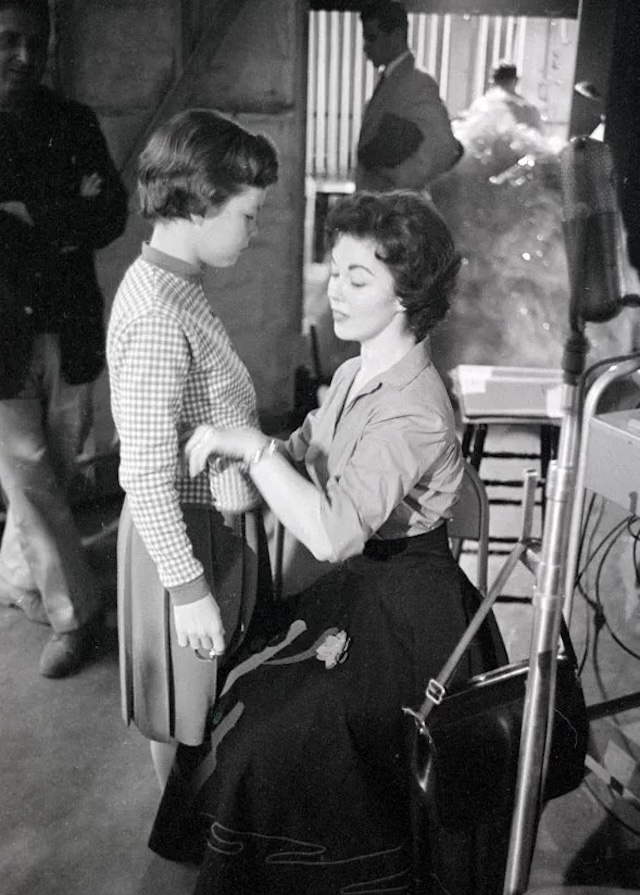 Behind the scenes, Shirley Temple offers motherly care and attention to Linda, embodying the role of a nurturing and attentive mother