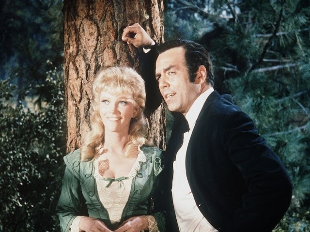 Kathie Browne and Pernell Roberts sharing a romantic moment in the woods, as their characters' relationship evolves in Bonanza