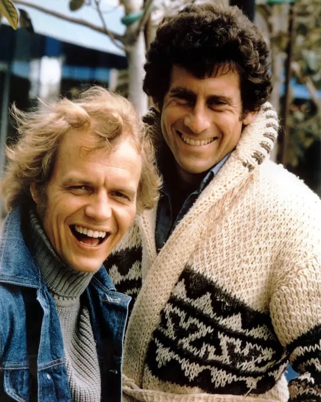 Behind-the-scenes laughter, a candid shot capturing the natural chemistry and friendship between Paul Michael Glaser and David Soul, the stars of Starsky & Hutch