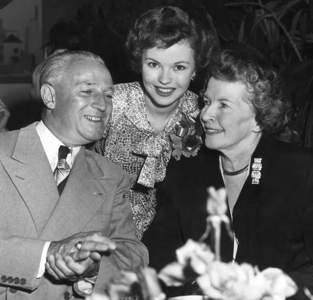 An adult Shirley with her parents, showing their lasting bond