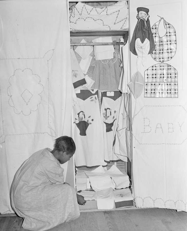 A young girl carefully arranging her sewing projects in a display, highlighting the detailed work taught in her Home Economics class.