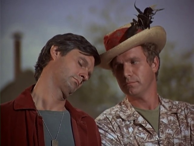 Hawkeye and Trapper share a lighthearted moment, with Trapper sporting a playful hat, showcasing the camaraderie and mischievous spirit that defined their relationship on M*A*S*H