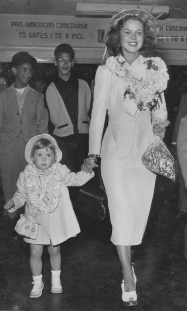 Shirley Temple and Linda Susan arrive at the airport hand-in-hand, dressed impeccably, reflecting the balance of Hollywood glamor and family life