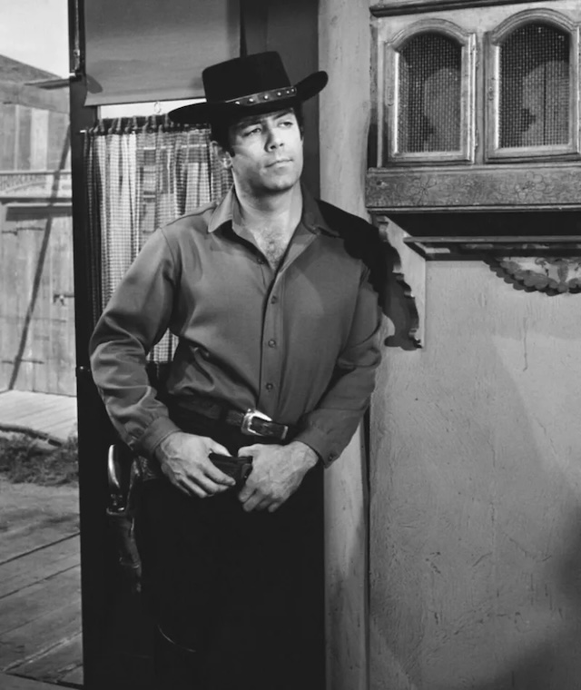 This striking black-and-white image captures Pernell Roberts in his iconic role as Adam Cartwright. Known for his rugged demeanor and thoughtful leadership, Adam was the eldest Cartwright son on Bonanza