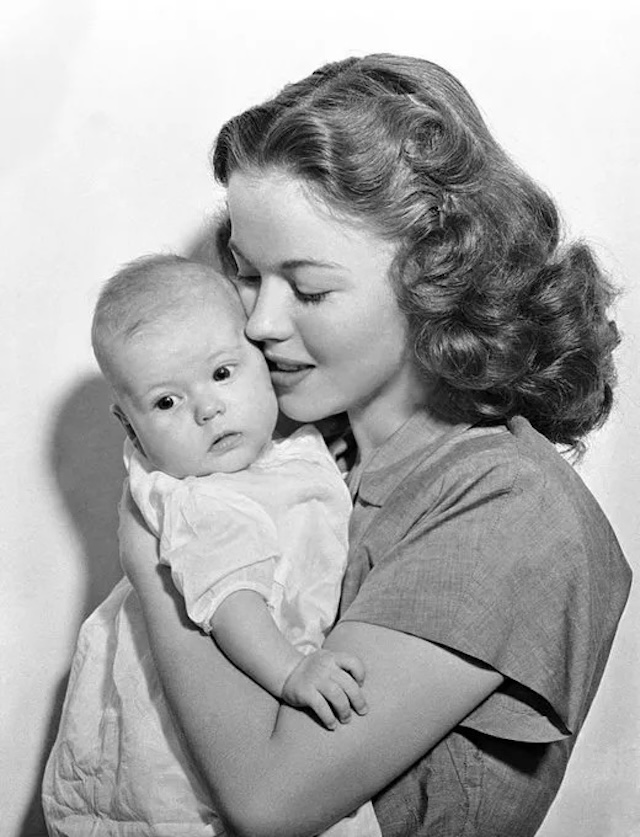 A touching image of Shirley Temple holding her baby daughter Linda, filled with maternal love and affection