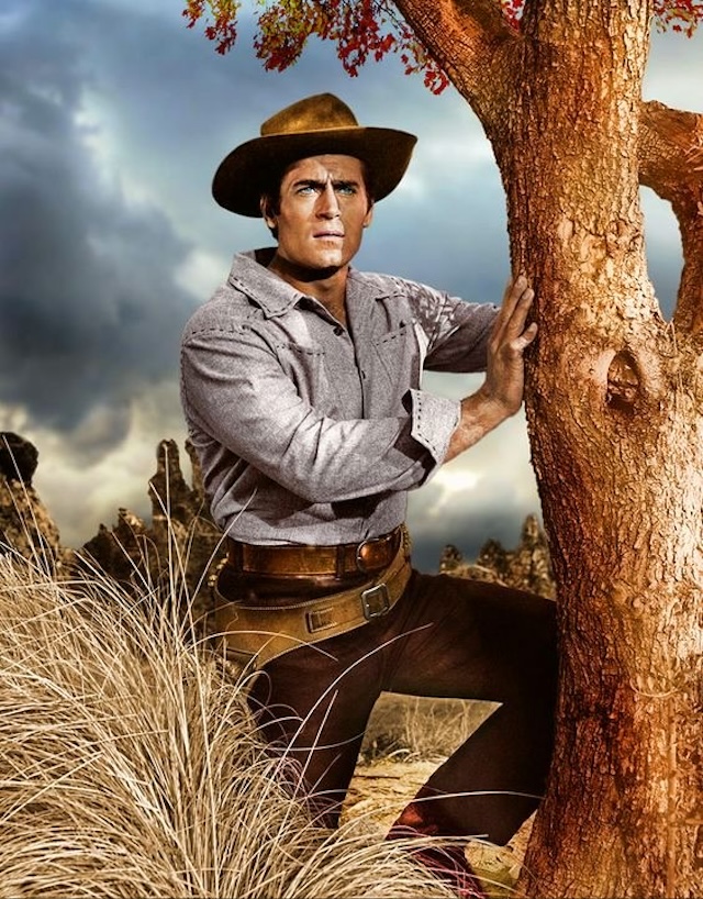 A heroic figure in the wilderness, Clint Walker poses in front of the rugged backdrop that defined the show’s Western atmosphere, perfectly capturing the essence of the frontier.