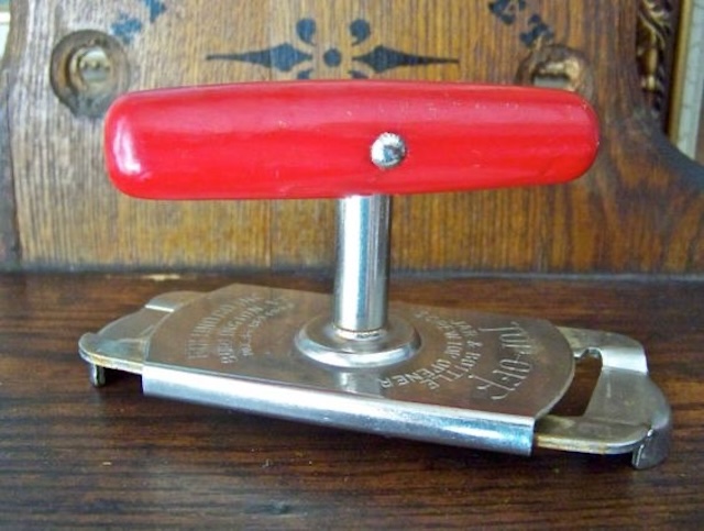 An iconic vintage jar opener with a red handle, ready to assist in opening even the most stubborn jars.