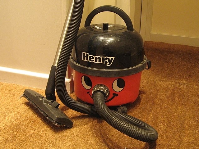 A classic vacuum cleaner with a durable hose designed to handle everyday cleaning tasks efficiently.