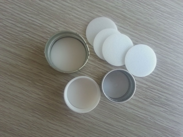 Various rubber liners are prepared to be inserted into bottle caps, helping to seal the bottles and preserve the drink's quality.