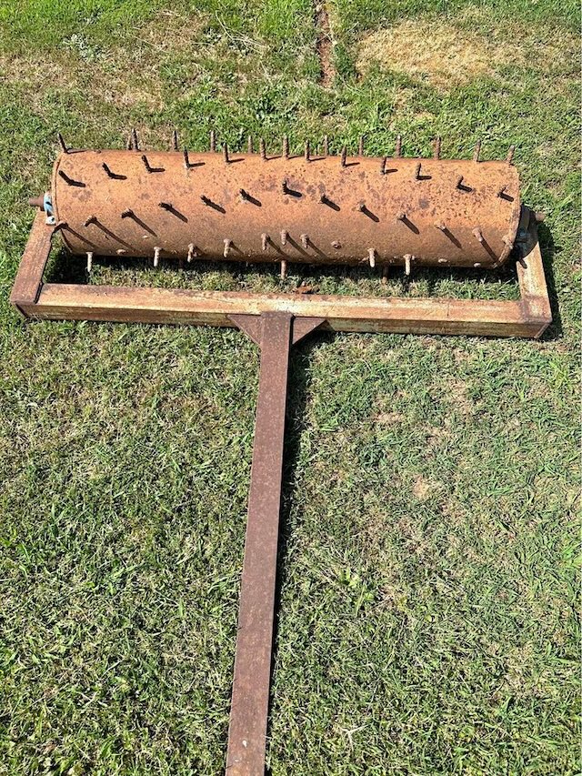 A closer look at a well-worn vintage aerator, showing its age yet retaining its utility for creating aeration holes in the soil