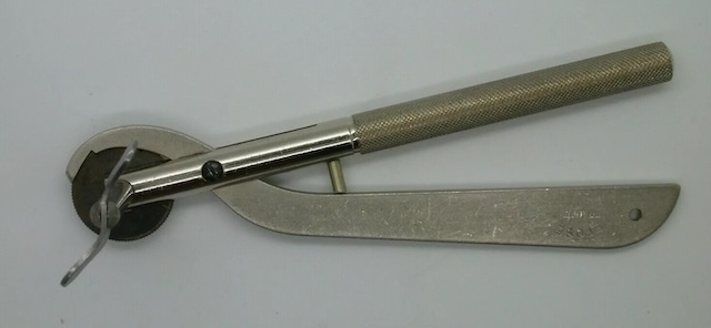 A close-up of the vintage ring cutter, showing its precise, knurled handle for a firm grip