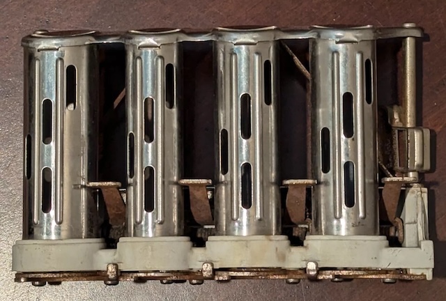 A close-up view of the aged metal compartments of the coin charger, showcasing its intricate and durable design