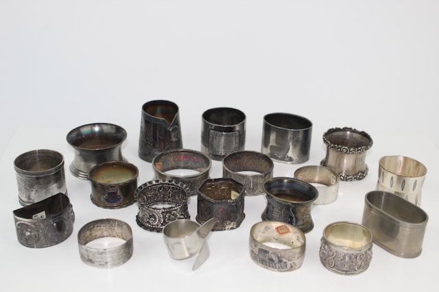 A collection of assorted vintage silver napkin rings, showcasing diverse craftsmanship and designs from different eras, each telling a story of a bygone dining culture.