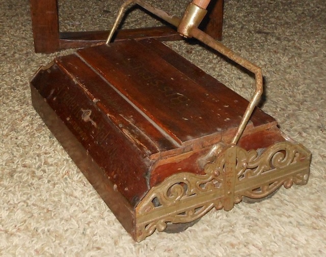 Captured in a homey setting, this vintage carpet sweeper still carries the charm and utility that made it a staple in households decades ago.