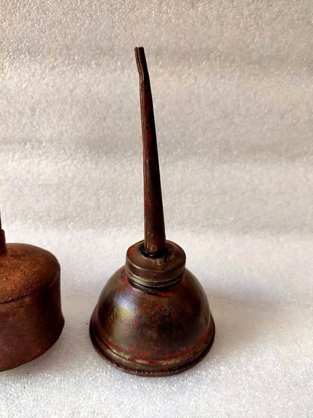 This rusted yet charming vintage midget oil can dispenser reveals its age, a tool that has witnessed countless repairs and care sessions over the year