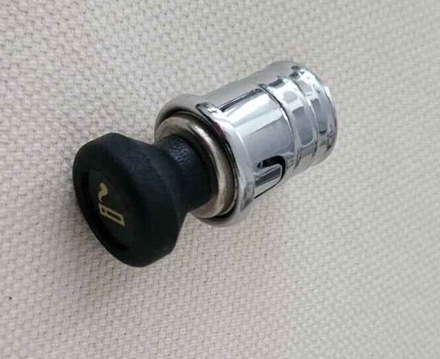 This classic car cigarette lighter plug features the recognizable smoking symbol, once a common sight in cars of the past