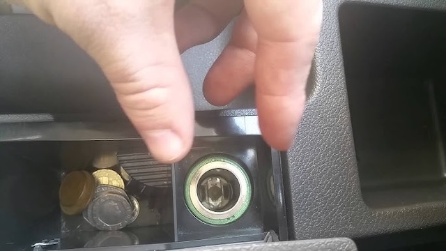 In modern cars, these lighters are often repurposed as power outlets, but here's a view of a classic cigarette lighter socket, now holding coins instead