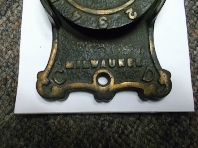 The bottom part of the plate, showing the “Milwaukee” city mark, where these plates were likely manufactured.