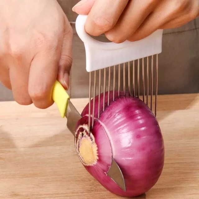 The stainless onion holder is used to slice a red onion with precision, demonstrating how this simple gadget can streamline kitchen tasks.