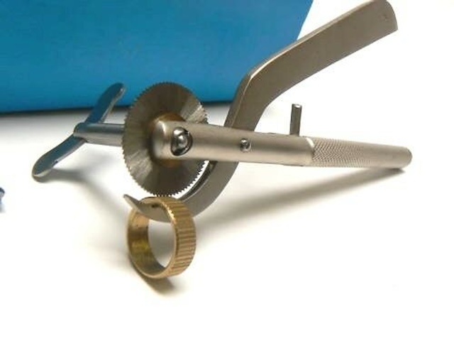 The vintage ring cutter mid-operation, showcasing its function with a ring being cut open